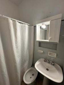 a bathroom with a sink and a toilet and a mirror at Continente Park in San Clemente del Tuyú +21 photos