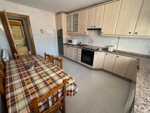 a kitchen with a table and a kitchen with white cabinets at Casa cerca de Las Medulas in Puente de Domingo Flórez
