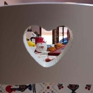 a heart shaped mirror on a wall with a plate of food at Sole in Quartu Sant'Elena +7 photos