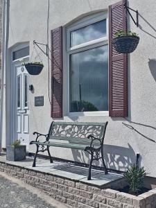 a bench sitting in front of a window at Copper Mine Cottage in Llandudno