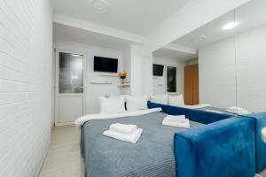 a bedroom with a blue bed with two white pillows at ERA Studios Chisinau in Chişinău
