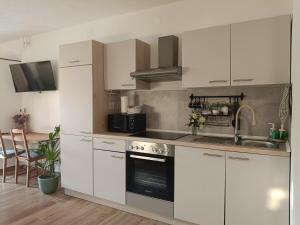 a kitchen with white cabinets and a stove top oven at Gravitacija East in Tolmin