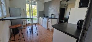 a kitchen with a counter and bar stools in it at Appartement St montan in Saint-Montan