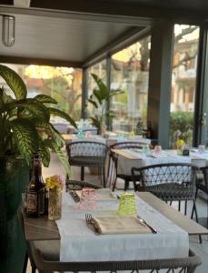ein Tisch in einem Restaurant mit Tischen und Stühlen in der Unterkunft Hotel Marolda in Sirmione + 39 Fotos