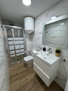 a white bathroom with a sink and a toilet at Ideal parejas Estudio Granadella en Jávea in Platja de l'Arenal