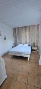 a bedroom with a bed and a wooden wall at Appartement St montan in Saint-Montan