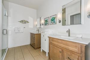 a white bathroom with a sink and a mirror at 477 Fort Pickens Rd. in Pensacola Beach +40 photos