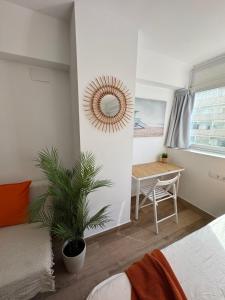 a bedroom with a bed and a mirror and a table at Ideal parejas Estudio Granadella en Jávea in Platja de l'Arenal