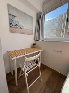 a table and chair in a room with a window at Ideal parejas Estudio Granadella en Jávea in Platja de l'Arenal