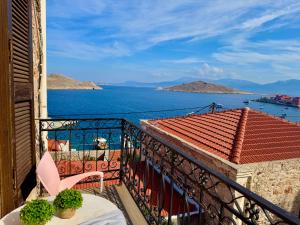 a balcony with a table and a view of the water at Maestro apartment Chalki in Halki