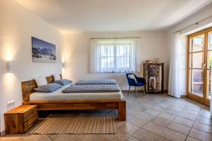 a bedroom with a bed and a blue chair at Haus Lara - Fewo 2 in Wallgau