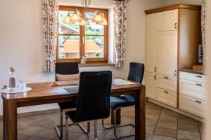 a kitchen with a wooden table and chairs at Haus Lara - Fewo 2 in Wallgau +5 photos
