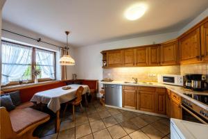 a kitchen with a table and a dining room at Haus Lara - Fewo 1 in Wallgau +8 photos