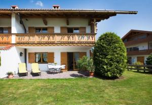 a house with a table and chairs in the yard at Haus Lara - Fewo 1 in Wallgau