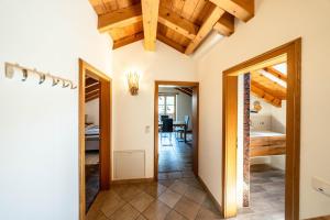 an open hallway with a kitchen and dining room with wooden ceilings at Haus Lara - Fewo 3 in Wallgau