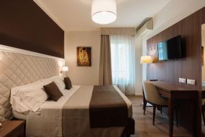 a hotel room with a bed and a desk at Hotel Eden Salò in Salò