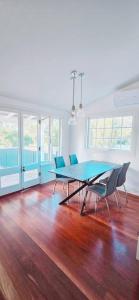 a dining room with a blue table and chairs at Full house - Heritage Charm Meets Modern Ease in Midland Junction