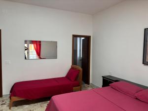 a bedroom with two beds and a chair and a window at Dayana House in Gallipoli