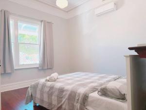 a white bedroom with a bed and a window at Full house - Heritage Charm Meets Modern Ease in Midland Junction +15 photos