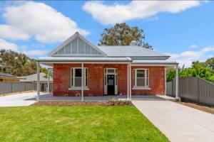 a red brick house with a green lawn at Full house - Heritage Charm Meets Modern Ease in Midland Junction