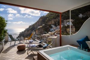 una vasca idromassaggio su un balcone con vista sull'oceano di Positano Art Hotel Pasitea a Positano