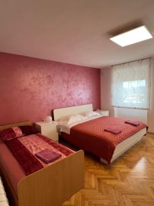 ein Schlafzimmer mit zwei Betten und einer rosa Wand in der Unterkunft Nedi's Nest - Cozy Countryside Retreat Under Palmtrees in Dutovlje