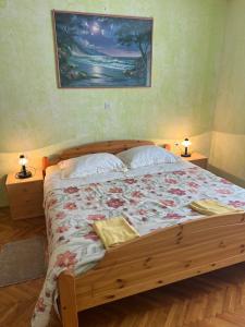 ein Schlafzimmer mit einem großen Holzbett und zwei Lampen in der Unterkunft Nedi's Nest - Cozy Countryside Retreat Under Palmtrees in Dutovlje