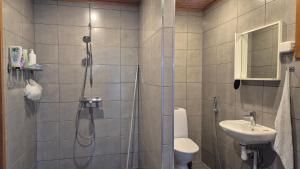 a bathroom with a shower and a toilet and a sink at Saunatupa Kajaani in Kajaani
