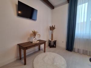 a living room with a table and a tv on the wall at Майдан house in Maidan Village