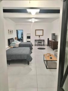 a bedroom with two beds and a living room at Depa Loft Monterrey cerca de Fundidora, Macroplaza y Barrio Antiguo in Monterrey