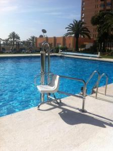 a white chair sitting next to a swimming pool at Hotel PYR, Spacious Studio with a Big Terrace in Fuengirola