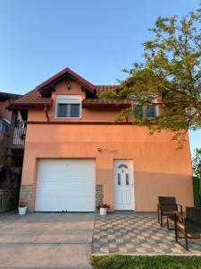 a orange house with a white garage door at Apartman N&M 2 in Temerin