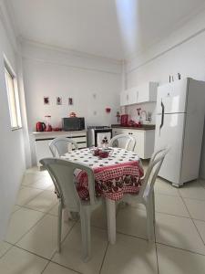 a kitchen with a table and chairs and a refrigerator at Morada Vermelha in Vitória da Conquista