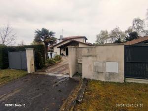a house with a gate in front of a driveway at Chambre Pessac proche rocade aéroport in Pessac