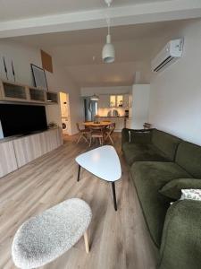 a living room with a green couch and a table at The Red Boat House in Vestmanna