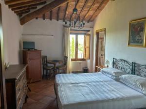 a bedroom with a bed and a table and a window at Hotel Casafrassi in Castellina in Chianti