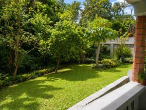 a yard with green grass and trees and a house at BtC Apartments St Paul's in Saint Paulʼs