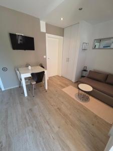 a living room with a couch and a table and a desk at Apartments A&A in Bibinje
