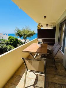 a balcony with a table and chairs and the ocean at Sophia's apartment in Saronida