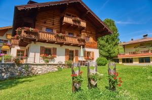 a wooden house with flowers in front of it at Haus Traudl in Filzmoos