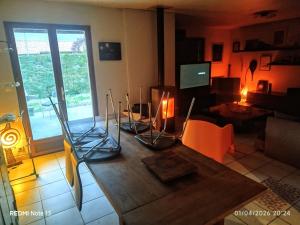 a living room with a table with chairs and a television at Chambre Pessac proche rocade aéroport in Pessac