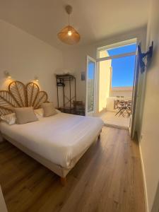 a bedroom with a large bed and a large window at Hôtel L'Oustaou in Le Lavandou +46 photos