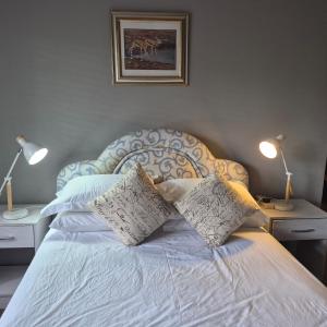 a bedroom with a bed with two pillows on it at Kleingeluk Guest Cottages in Louis Trichardt