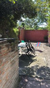 a patio with a table and chairs in a backyard at Casa Mitre in Luján