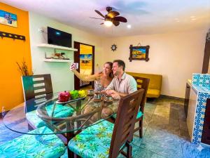 a man and woman sitting at a glass table at Cande's Apartments in Isla Mujeres