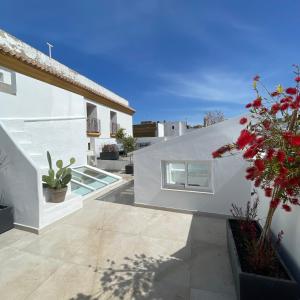 a white house with a courtyard with potted plants at Casa Florinda Tarifa in Tarifa