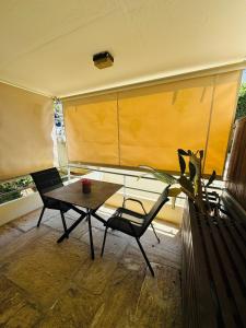 a living room with a table and chairs and a window at Sophia's studio in Saronida