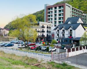 a parking lot with cars parked in front of a building at Pensiunea LOFT Căciulata in Caciulata