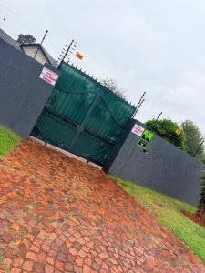 a fence with a gate on top of a brick yard at The Stillhouse Guest House in Edenvale
