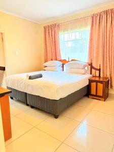 a large bed in a room with a large window at The Stillhouse Guest House in Edenvale